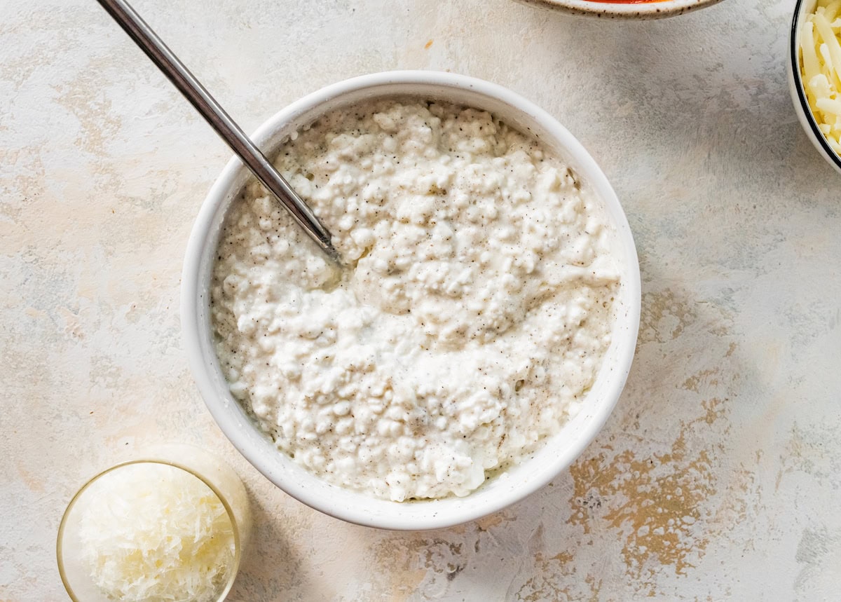 A mixture of cottage cheese and egg whites in a small bowl.