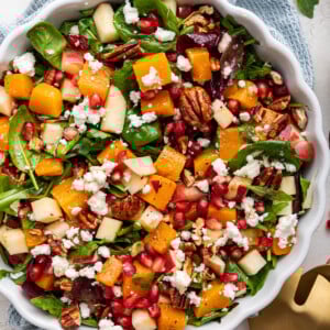 Winter salad being served in a white bowl.